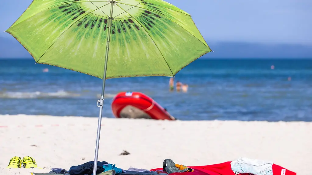 Ein-grosser-Sonnenschirm-steht-am-Strand-an-der-Ostseekueste