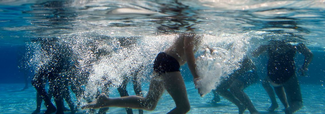 Kinder spielen in einem Freibad.