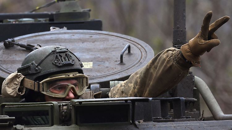 Ein ukrainischer Panzerfahrer zeigt sich auf seinem Weg zur Front in Tschassiw Jar siegessicher.