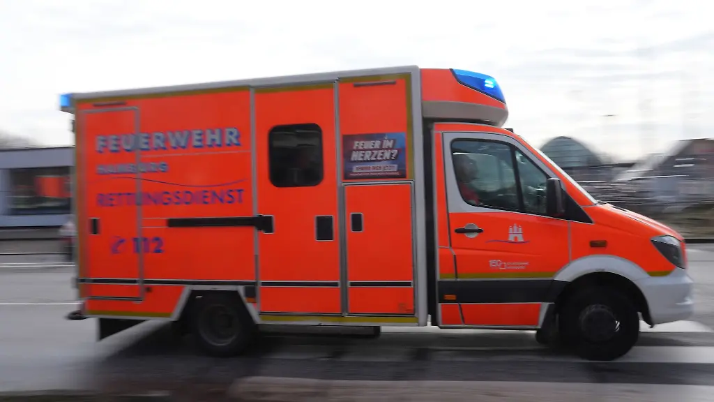 Ein-Rettungswagen-RTW-der-Feuerwehr-faehrt-mit-Blaulicht-zu-einem-Einsatz