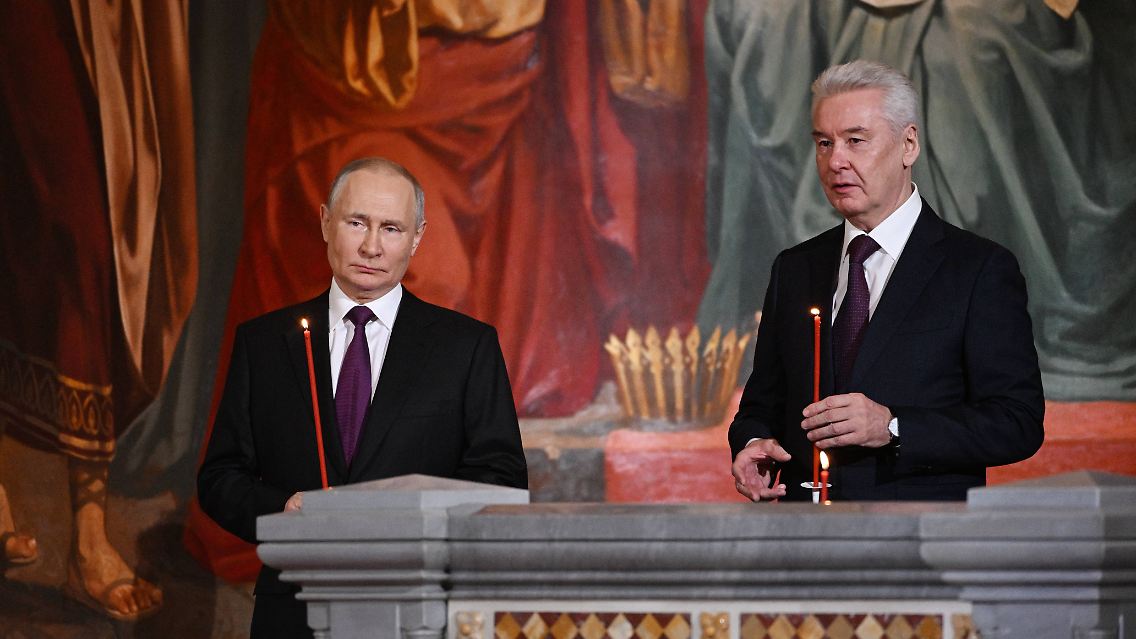 Auf Fotos ist zu sehen, wie Putin (l.) und Moskaus Bürgermeister Sobjanin mit Kerzen in den Händen nebeneinander stehen.