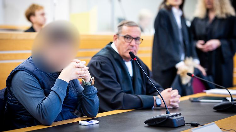 Die beiden Angeklagten (vorne links und oben Mitte) sitzen im Gerichtssaal im Landgericht Hannover.