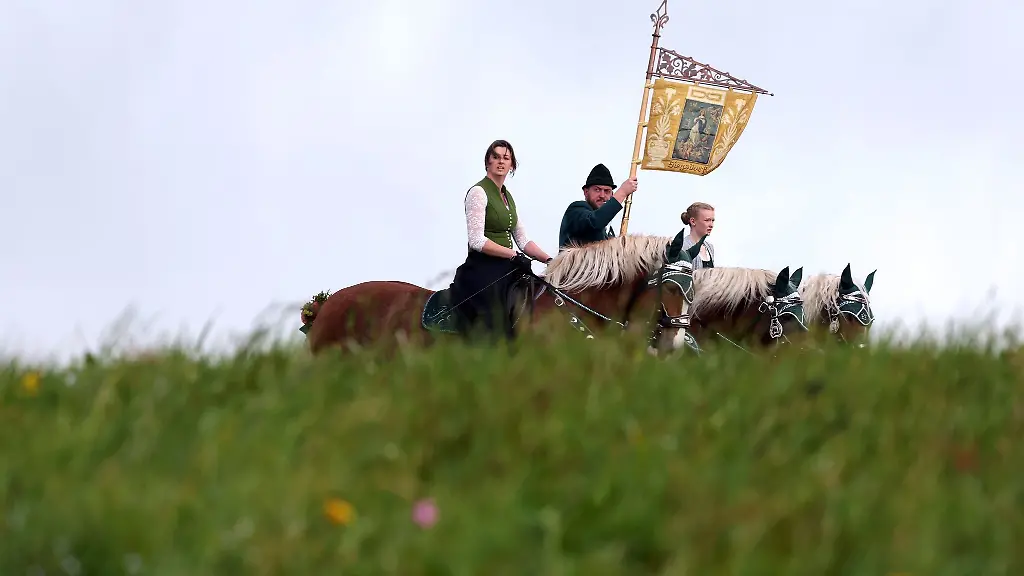 Reiter-mit-festlich-geschmueckten-Roessern-ziehen-am-Ostermontag-beim-traditionellen-Georgi-Ritt-zur-Kirche-von-Ettendorf