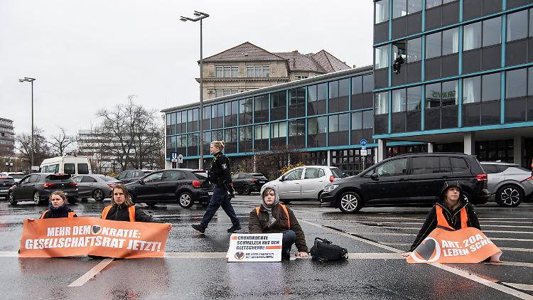 Klimaaktivisten der Letzten Generation blockieren einen großen Kreisverkehr in Berlin.