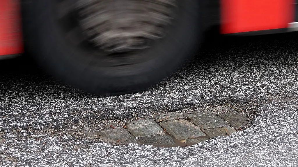 Ein-Bus-faehrt-an-einem-Schlagloch-auf-dem-Mittelweg-im-Stadtteil-Rotherbaum-vorbei-Aufnahme-mit-laengerer-Verschlusszeit