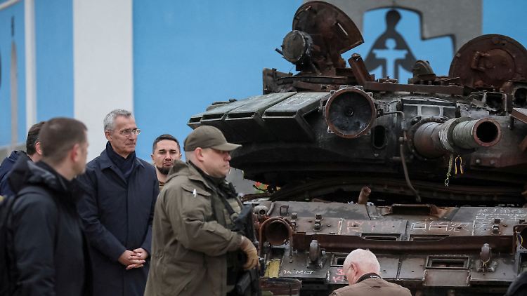 Stoltenberg begutachtet abgeschirmt zerstörte russische Panzer.