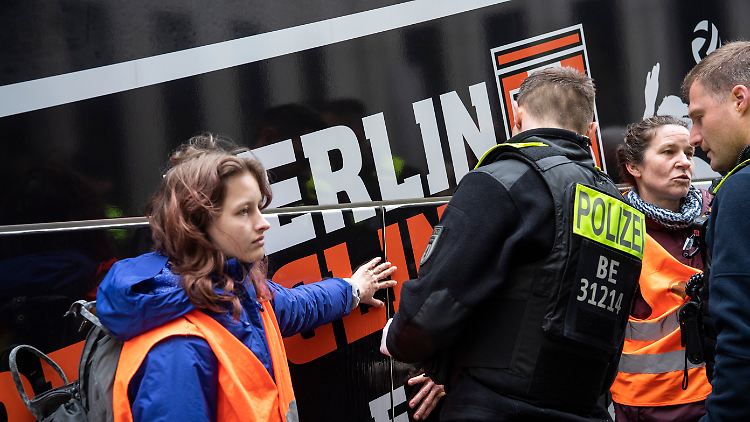In der Nähe des Potsdamer Platzes klebten sich vier Aktivisten an einem Reisebus fest.