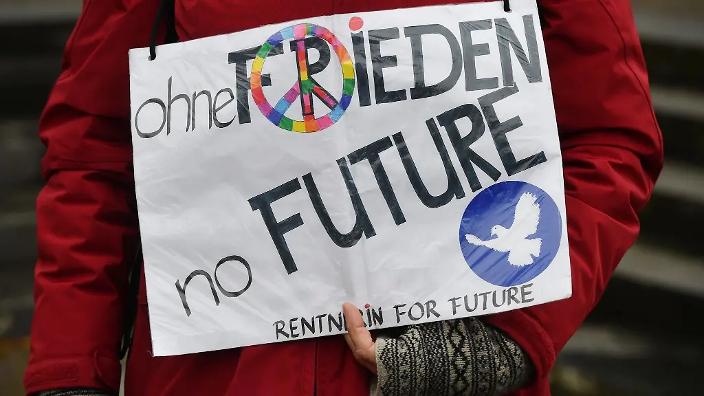 ohne-Frieden-no-Future-Rentnerin-for-future-steht-auf-einem-Plakat-das-eine-Frau-am-Ostermontag-zum-Abschluss-des-Ostermarsch-Rhein-Ruhr-2021-zeigt