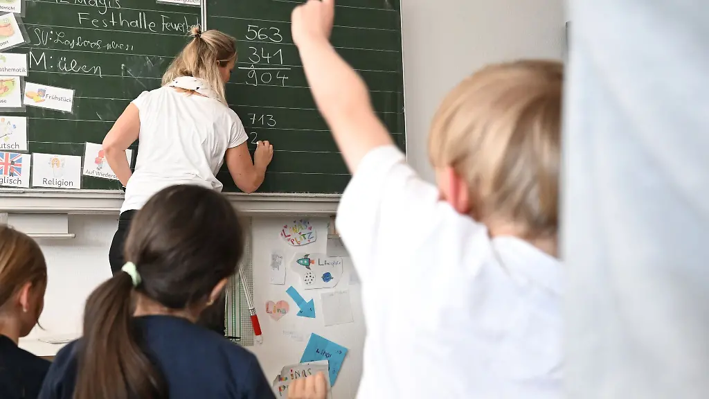 Schueler-einer-Grundschule-arbeiten-in-einem-Klassenzimmer-an-Mathematikaufgaben