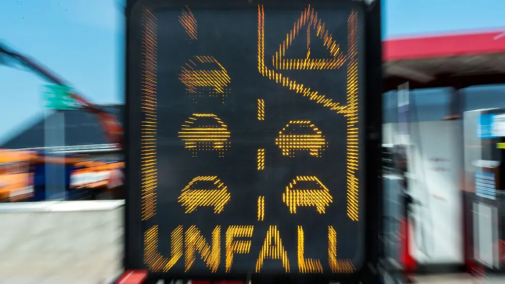 Ein-Sicherungsanhaenger-mit-einer-elektronischen-Warnung-vor-einem-Unfall-steht-auf-einer-Autobahn