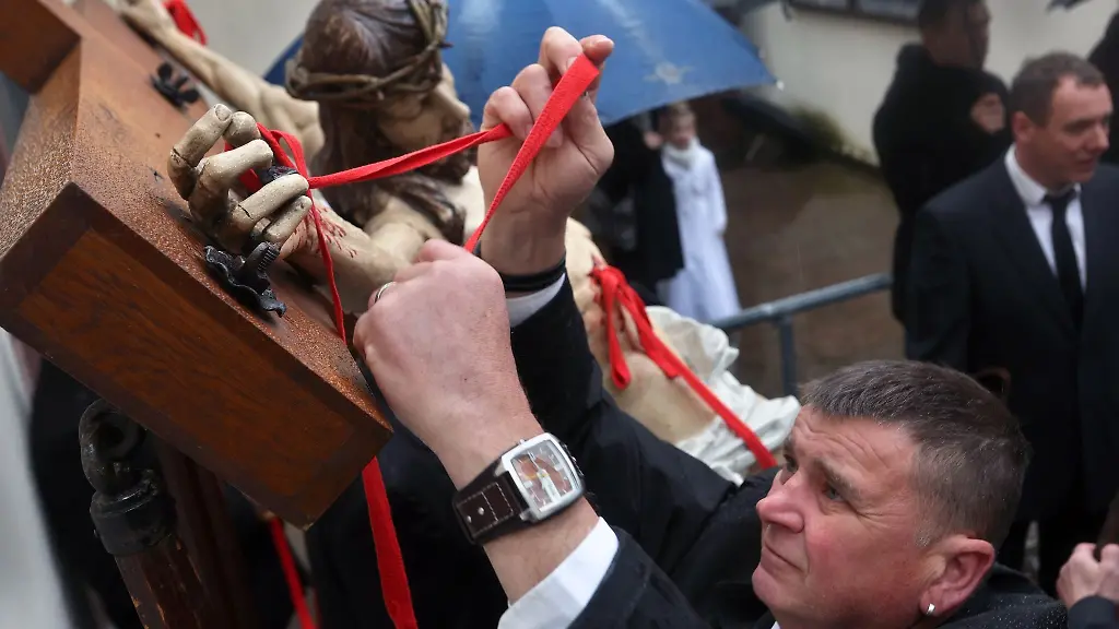 Angehoerige-verschiedener-Handwerkszuenfte-bereiten-ein-Kreuz-mit-Jesusfigur-fuer-die-Karfreitagsprozession-vor