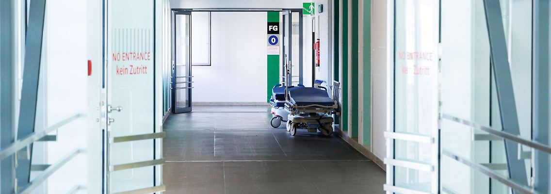 Krankenbetten stehen in einem Gang in einem Krankenhaus.