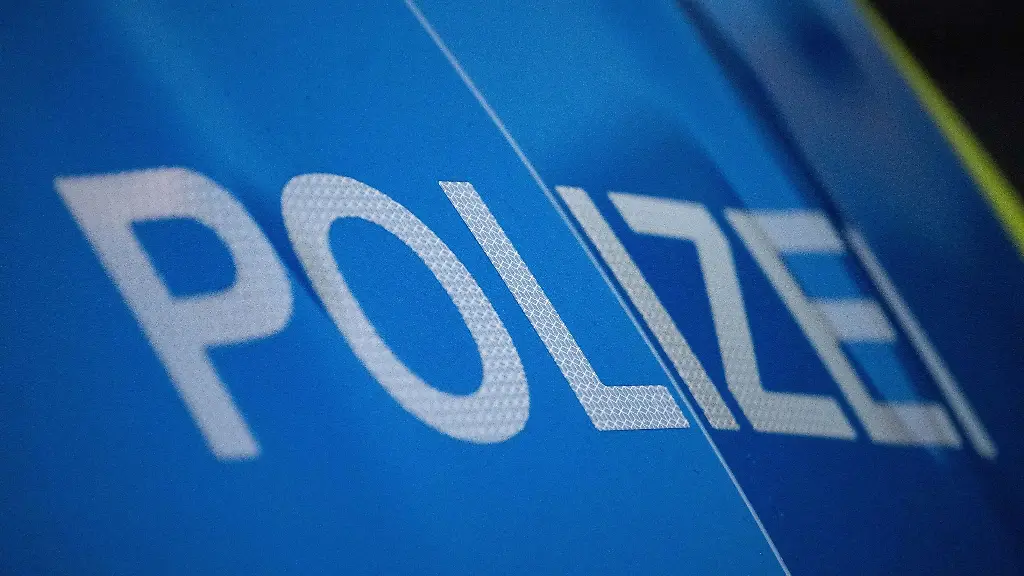 Das-Wort-Polizei-ist-auf-der-Karosserie-eines-Polizeifahrzeugs-zu-sehen