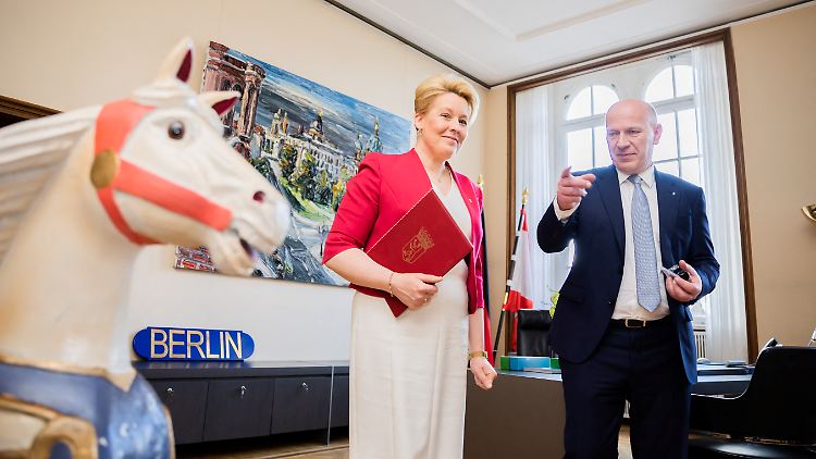 Franziska Giffey, Kai Wegner und ein Schaukelpferd bei der Amtsübergabe im Roten Rathaus. Das Schaukelpferd steht schon länger dort, es ist kein Geschenk der Sozialdemokratin an ihren Nachfolger.