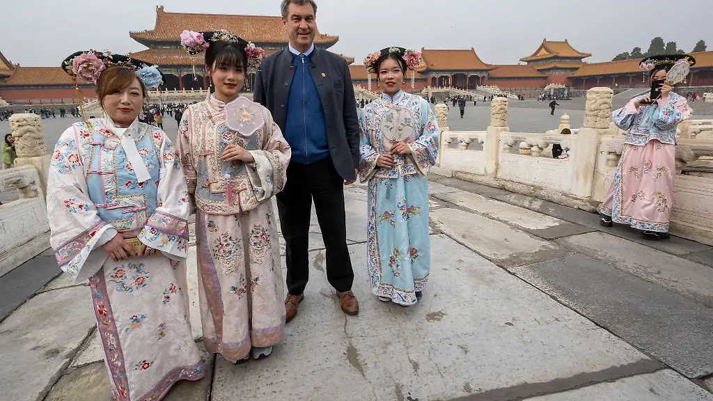 Markus-Soeder-besucht-die-historische-verbotene-Stadt-in-der-chinesischen-Hauptstadt-und-steht-neben-Frauen-in-traditionellen-Kostuemen