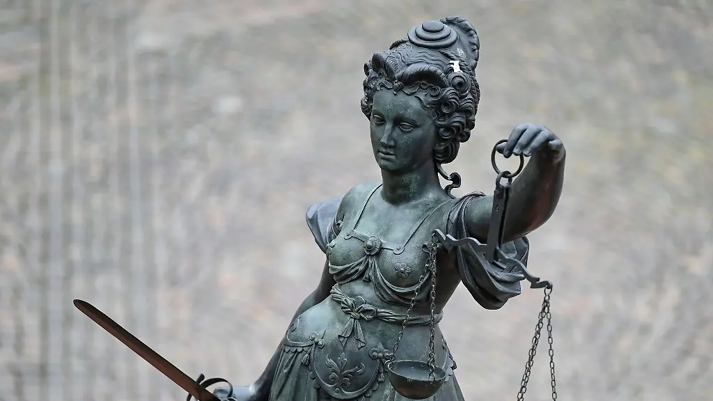 Eine-Statue-der-Justitia-haelt-eine-Waage-und-ein-Schwert-in-der-Hand