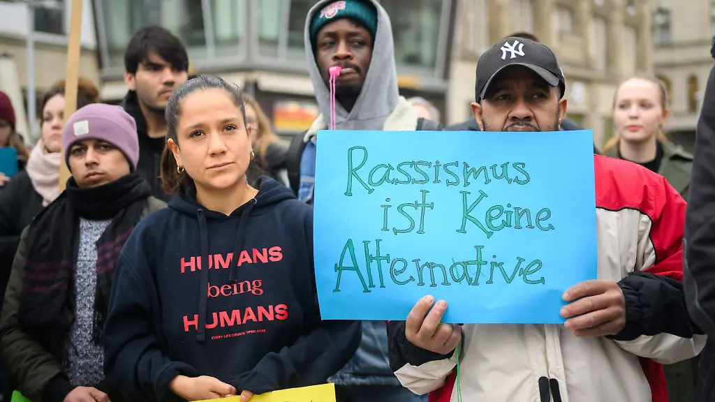 Mit-beschrifteten-Kleidungsstuecken-und-Schildern-demonstrieren-Menschen-bei-einer-Veranstaltung-am-Kroepke