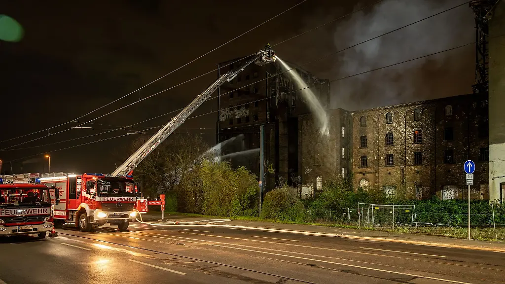 Einsatzkraefte-der-Feuerwehr-loeschen-den-Brand-in-einem-leerstehenden-Gebaeude