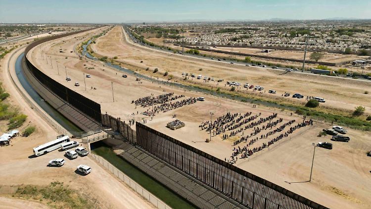 Migranten warten auf dem Grenzstreifen am texanischen El Paso.