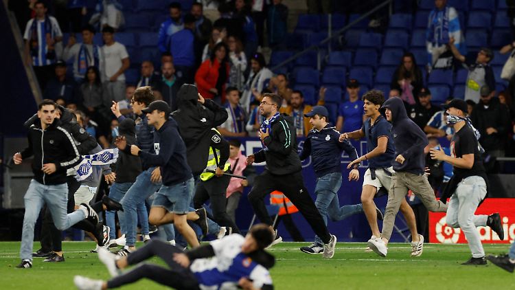 Fans von Espanyol stürmen aufs Feld, um den Titeltanz von Barças Spielern zu stören.