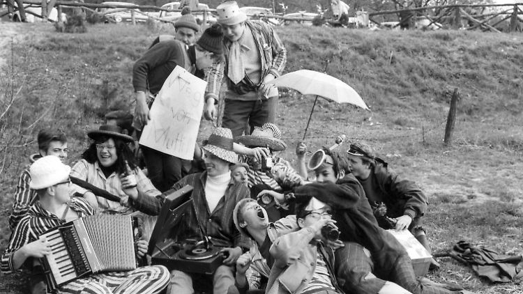 Eine ausgelassene Gesellschaft trinkt am Vatertag 1967 am Strand der Havel in Berlin Bier und musiziert.