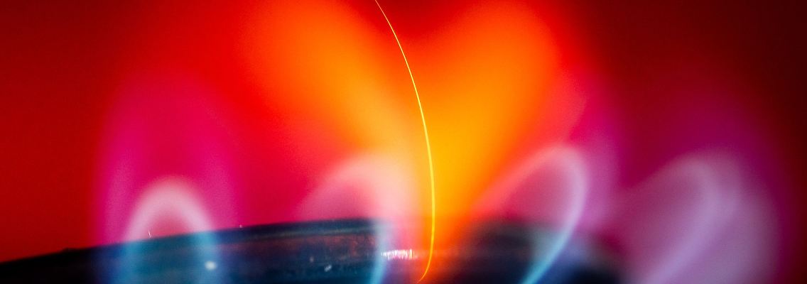 Flamme eines Gasherdes. Haben mehrere Gasversorger die Gaspreisbremse zu Unrecht ausgenutzt?