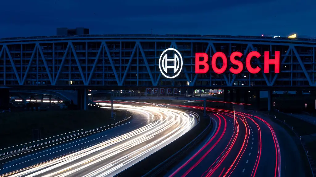 Das-Logo-des-Technologiekonzerns-Bosch-leuchtet-auf-einem-Parkhaus-der-Messe-Stuttgart-ueber-der-A8