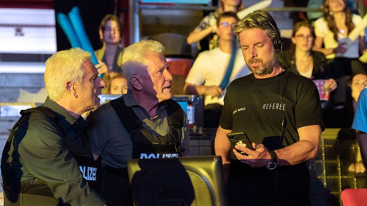 Franz Leitmayr (Udo Wachtveitl) und Ivo Batic (Miroslav Nemec) zeigen Referee (Danny Rosness) ein Foto.