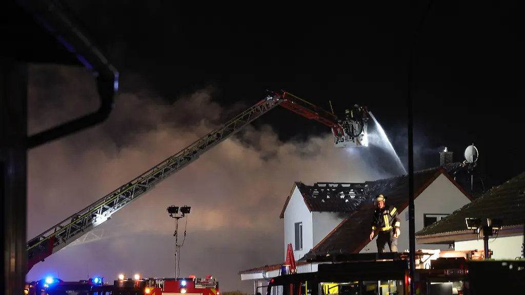 Einsatzkraefte-der-Feuerwehr-loeschen-einen-Wohnhausbrand-im-Main-Kinzig-Kreis
