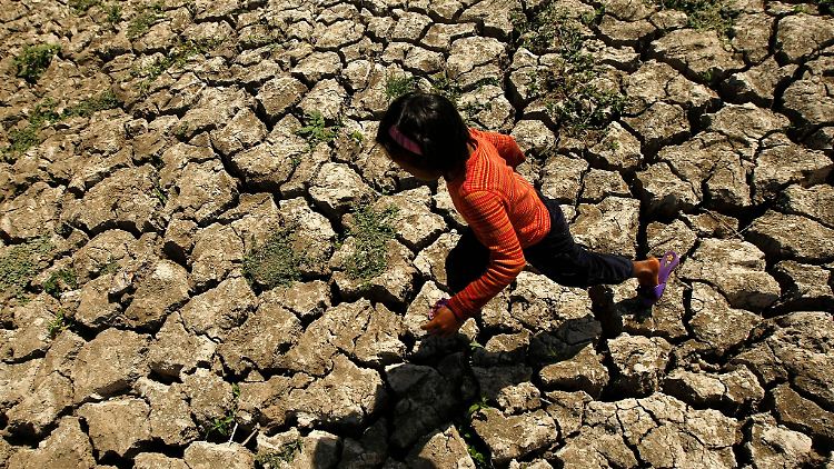 Ein philippinisches Kind läuft in der Provinz Cavite auf den Philippinen in einem ausgetrockneten Bewässerungskanal, der durch das Wetterphänomen "El Niño" ausgetrocknet war.