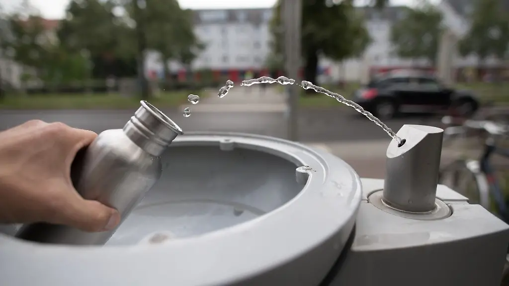 An-einem-Wasserspender-fuellt-sich-ein-Passant-seine-Trinkflasche-mit-Wasser-auf