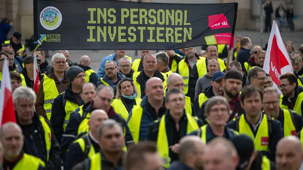Zahlreiche-Mitarbeiter-der-streikenden-Verkehrsbetriebe-aus-Brandenburg-demonstrieren-auf-dem-Alter-Markt-mit-einem-Transparent-mit-der-Aufschrift-Ins-Personal-investieren