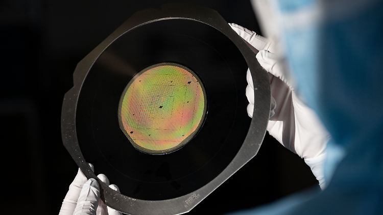 Eine Mitarbeiterin von Trumpf kontrolliert einen Wafer, der Grundlage für moderne Halbleiter ist.