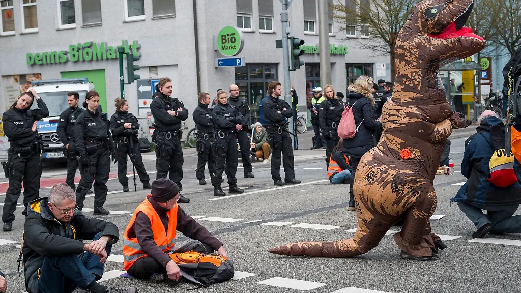 Demonstrantinnen-und-Demonstranten-die-auf-der-Strasse-sitzen-blockieren-die-Kreuzung-Kumpfmuehler-Str-und-Fritz-Fend-Strasse