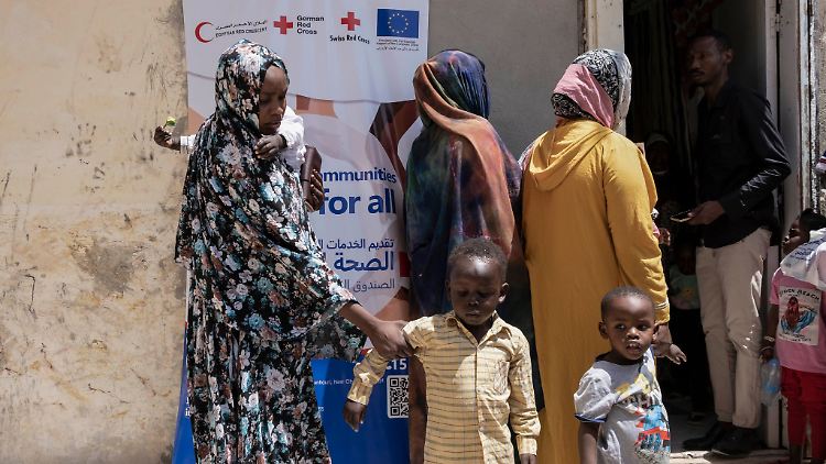 Sudanesische Flüchtlinge vor dem Gelände eines medizinischen Konvois für Neuankömmlinge in Ägypten.