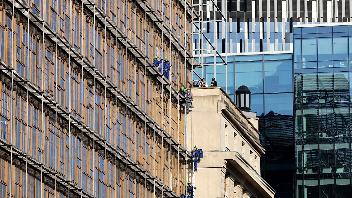 Mit Hilfe von Leitern klettern die Umweltschützer die Fassade hoch.