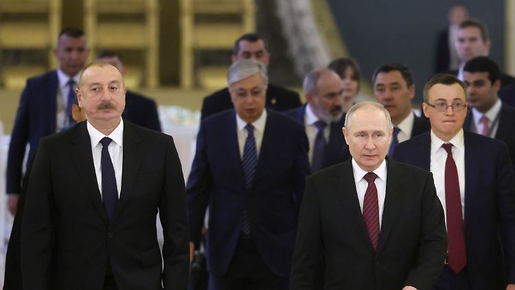 Putin schreitet vorn, links mit Schnurrbart ist der Präsident Aserbaidschans Alijew zu sehen, etwas weiter hinten mit Vollbart der armenische Premier Paschinjan.