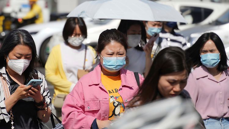 In China gehen auch bei frühsommerlichen Temperaturen viele Menschen nach wie vor lieber mit Maske auf die Straße.