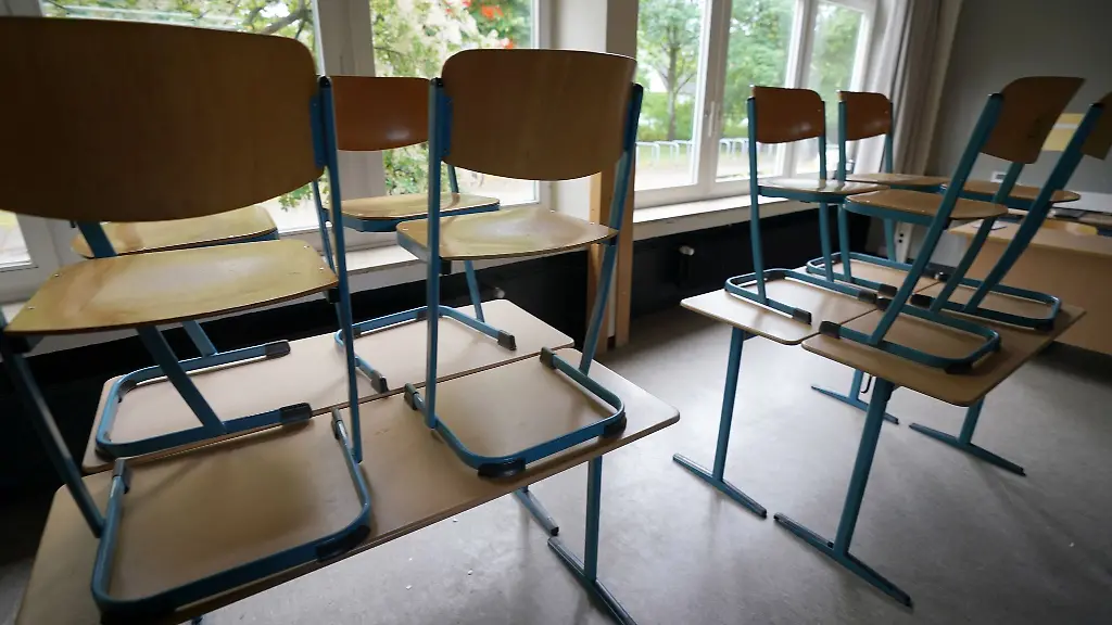 Stuehle-stehen-in-einem-Klassenraum-in-einer-Schule-auf-den-Tischen