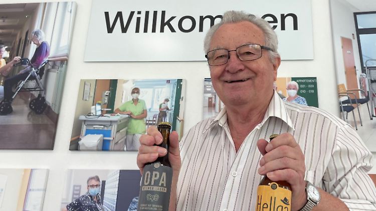 Rentner Helmut Riegerbauer gehört zum Team der Bierbrauer und zeigt zwei Flaschen aus eigener Produktion.