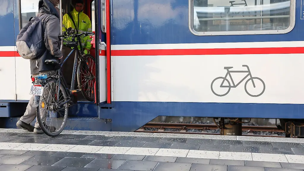 Ein-Mann-muss-sein-Fahrrad-in-den-Zug-heben
