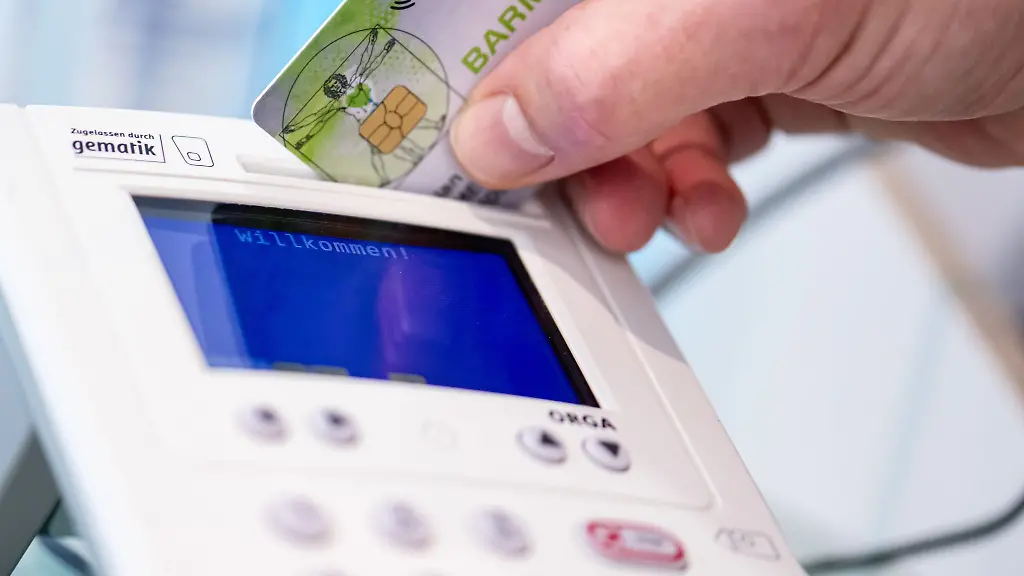 Ein-Mitarbeiter-einer-Apotheke-steckt-eine-Gesundheitskarte-in-ein-Lesegeraet