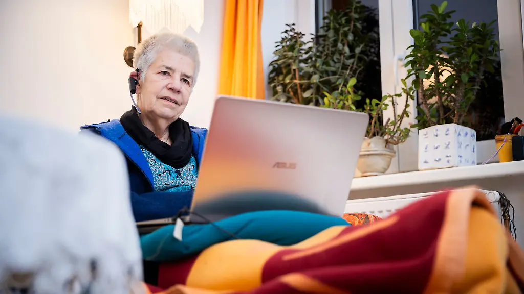 Elke-Schilling-Gruenderin-von-Silbernetz-telefoniert-im-Home-office-auf-ihrem-Sofa-sitzend-von-ihrer-Berliner-Wohnung-aus