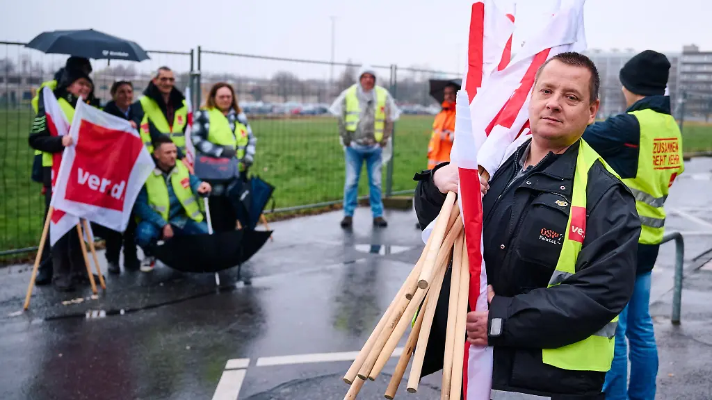 Ein-Gewerkschaftler-traegt-die-Fahnen-vom-Gelaende-Im-kommunalen-Nahverkehr-von-Nordrhein-Westfalen-drohen-Streiks