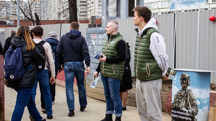 Männer versuchen, in Moskau Freiwillige für den Militärdienst zu rekrutieren. 
