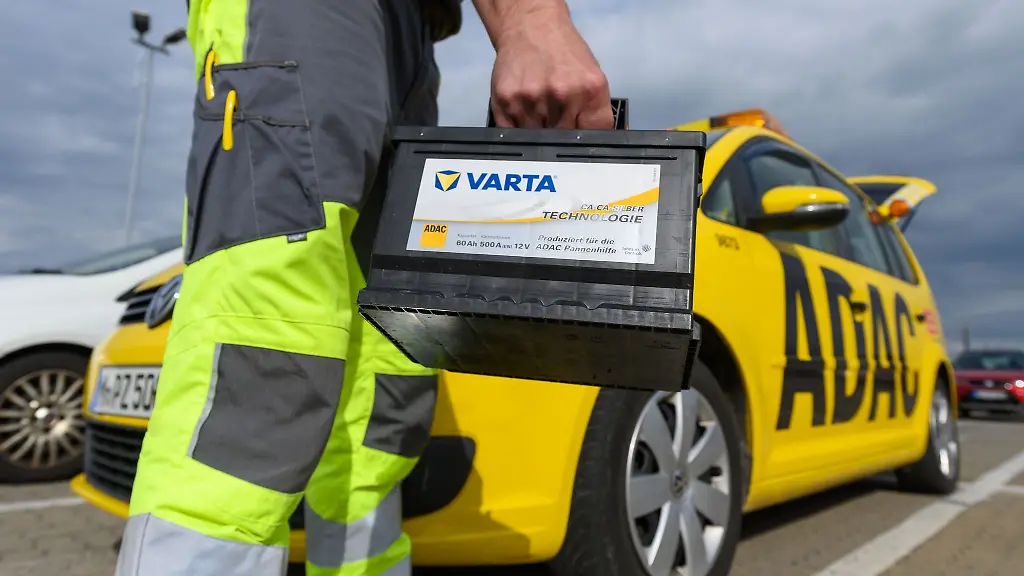 Ein-Pannenhelfer-der-ADAC-Strassenwacht-traegt-eine-Autobatterie