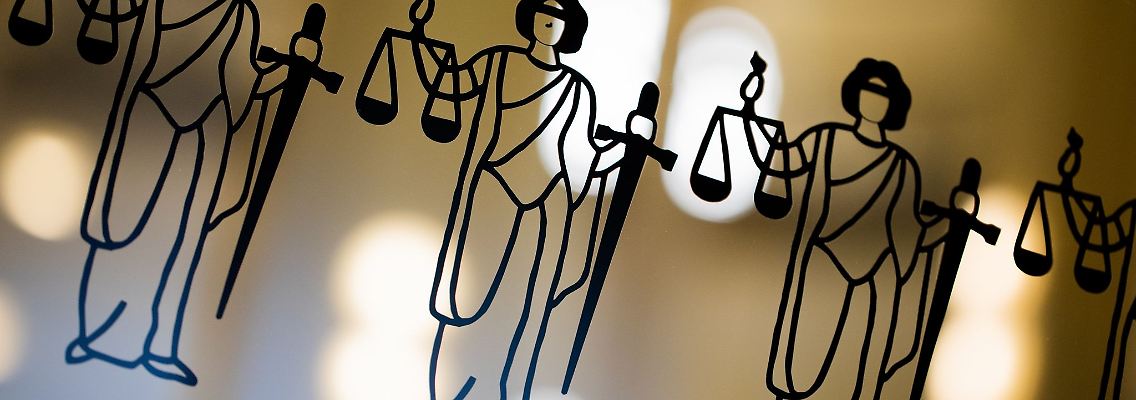 Die Justitia ist an einer Scheibe am Eingang zum Oberlandesgericht zu sehen.