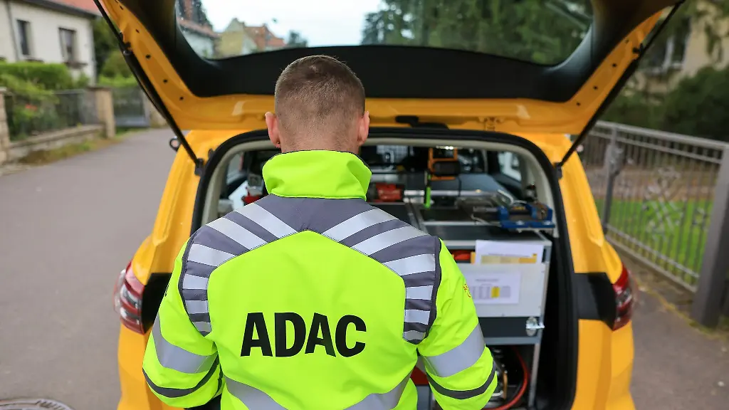 Ein-ADAC-Pannenhelfer-steht-nach-einer-Pannenhilfe-am-Kofferraum-seines-Fahrzeugs