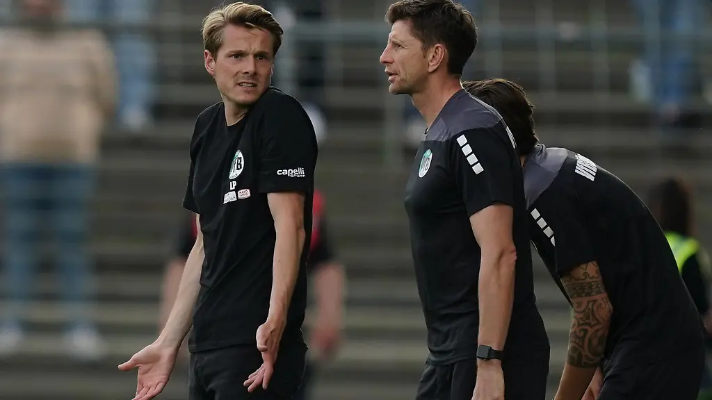 Luebecks-Trainer-Lukas-Pfeiffer-l-steht-neben-Luebecks-Co-Trainer-Bastian-Reinhardt-am-Spielfeldrand