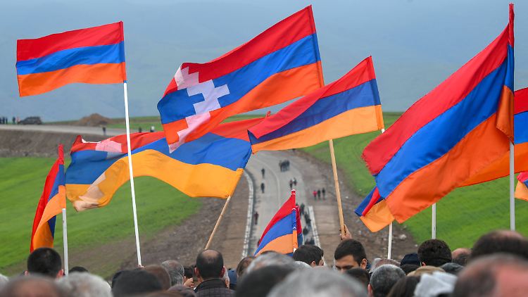 Demonstranten tragen bei einer Kundgebung Flaggen von Armenien und dem De-facto-Staat Bergkarabach.